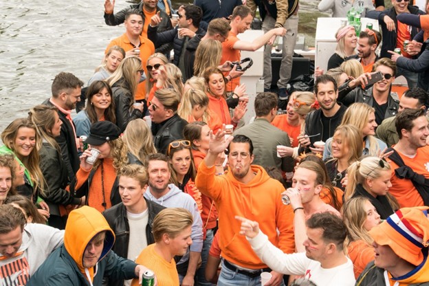 Mensen in het oranje vieren feest op een boot